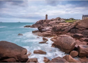 Le phare de Mean Ruz à Ploumanac'h illuminé par le soleil couchant sur les rochers de granit rose.