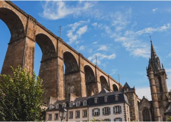 Vue en contre-plongée du Viaduc de Morlaix en pierre surplombant les maisons à pans de bois et le port. © Baroudeurs Liegeois