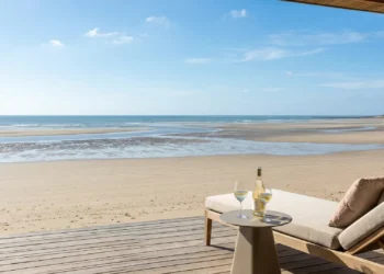 Vue élégante et lumineuse depuis la terrasse d'un hôtel de luxe donnant sur l'immense étendue de sable de la Lieue de Grève à marée basse.